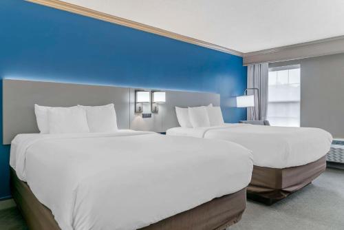 two beds in a hotel room with blue walls at Comfort Inn in Plainwell