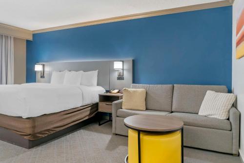 a hotel room with a bed and a couch at Comfort Inn in Plainwell