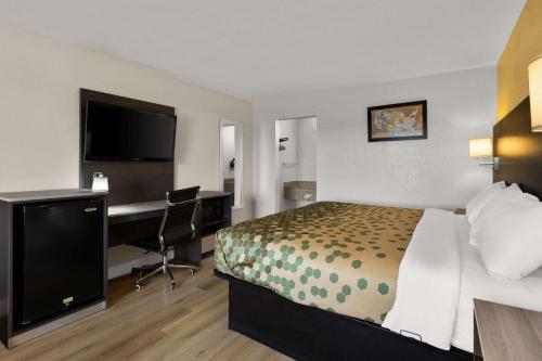 a hotel room with a bed and a desk at Econo Lodge White Pine Morristown I-81 & I-40 Split in White Pine
