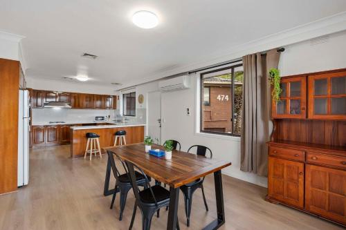 a kitchen and dining room with a wooden table and chairs at Econo Lodge Lilydale in Lilydale