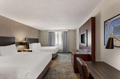 a hotel room with two beds and a desk at The Clover Hotel, Ascend Hotel Collection in South Bend