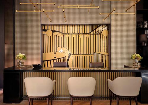 un salón con sillas blancas y espejo en art'otel Zagreb, Powered by Radisson Hotels en Zagreb
