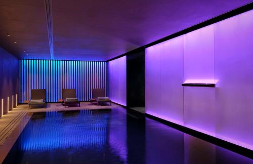 um quarto com uma piscina com luzes roxas em art'otel Zagreb, Powered by Radisson Hotels em Zagreb