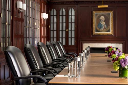 a long table in a room with chairs and flowers at Hilton Boston Park Plaza in Boston