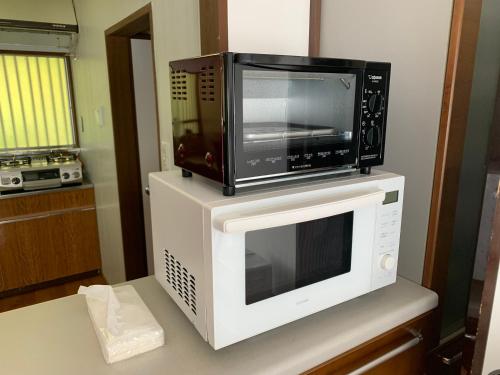a microwave sitting on top of a kitchen counter at ステイビレッジ蔵王　一棟丸貸し宿泊施設4名様まで同一金額　ペット同伴可！ in To-katta