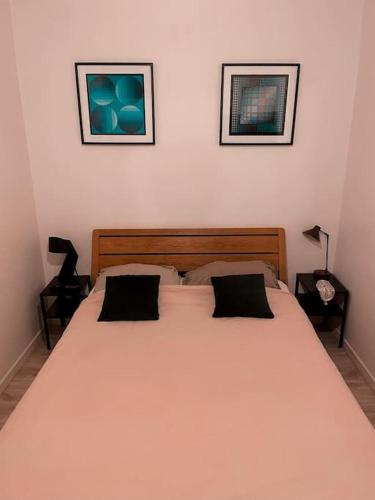 un lit dans une chambre avec deux tableaux au mur dans l'établissement 50m2 private apartment in center, à Paris