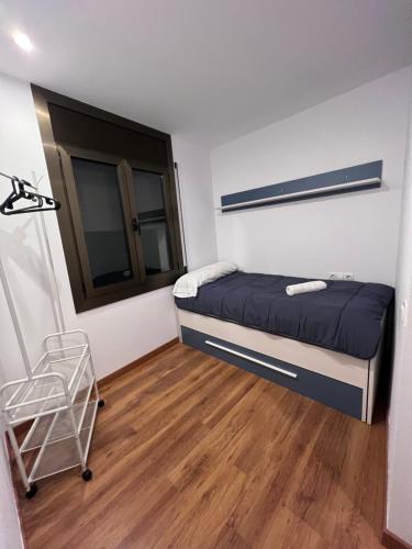 a small bedroom with a bed and a wooden floor at Piso Andorra in Andorra la Vella