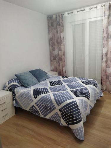 - une chambre avec un lit et une couette bleue et blanche dans l'établissement Habitación doble, à Astigarraga