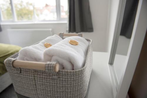 a basket filled with towels in front of a mirror at Mowbray Quarters of Cambridge in Cambridge