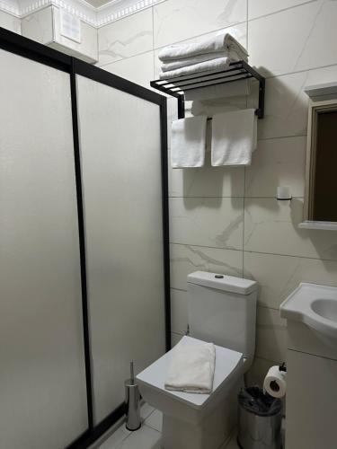 a bathroom with a toilet and a sink and towels at Loft House in Arnavutköy