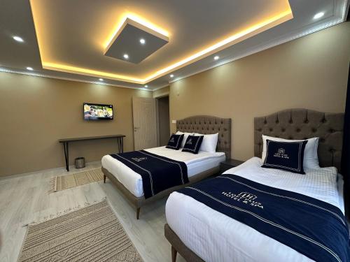 a hotel room with two beds and a tv at Loft House in Arnavutköy