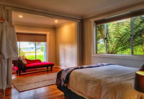 a bedroom with a bed and a window and a red chair at Castaway Cottage in Dover