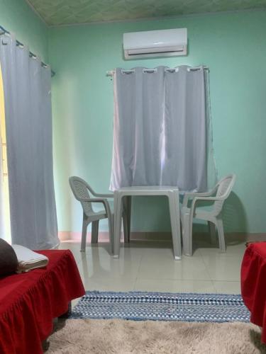 a living room with a table and two chairs at Quarto privativo,não é compartilhado! in Parauapebas