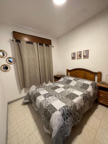 ein Schlafzimmer mit einem Bett mit einer Decke darauf in der Unterkunft Casa grande 3 dormitorios playa alvorada in Barra del Chuy
