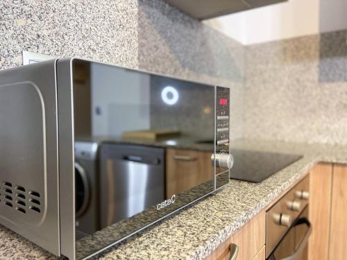 a microwave oven sitting on a counter in a kitchen at Vistas PRECIOSAS Al Valle De Arinsal - 6PAX- A Pie De Pistas & ESQUÍ - Free Parking l by BonesVacances in Arinsal