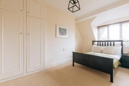 a bedroom with a black bed and a window at Bright & Delightful 2BD Flat Clifton Down Bristol in Bristol