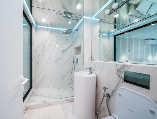 a white bathroom with a toilet and a sink at Emirates White Sensation in Sofia