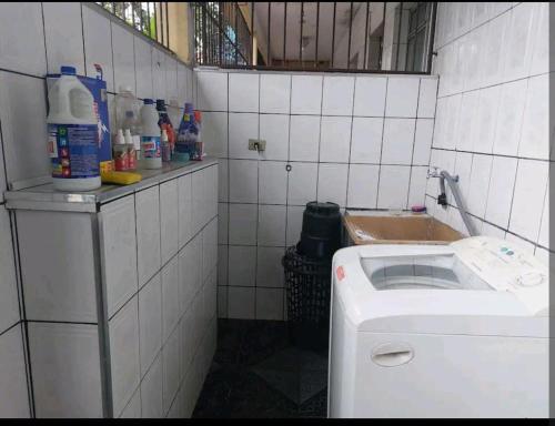 eine geflieste Küche mit einer Waschmaschine und einem Waschbecken in der Unterkunft Casa no ABC perto de São Paulo Expo e Jd botanico in São Paulo