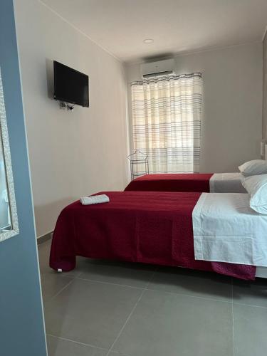 a bedroom with two beds and a flat screen tv at A Due Passi dal Mare in Catanzaro