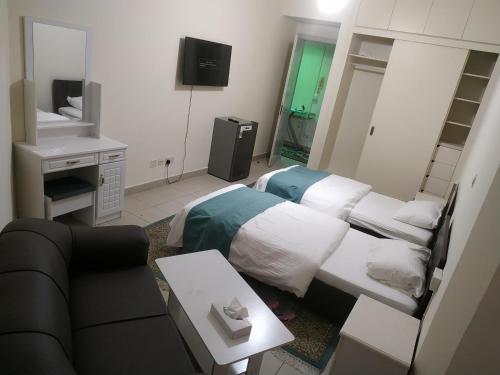 Ruby Star Hostel Dubai F 4 R 2-3 في دبي: غرفة فندقية بسريرين واريكة