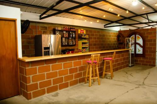 a brick bar with stools in a brick wall at CASA HOTEL LOS ARBOLES in Bello