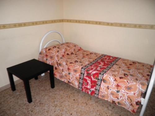 カタンザーロにあるIl Filo Di Ariannaの小さなベッドルーム(ベッド1台、テーブル付)