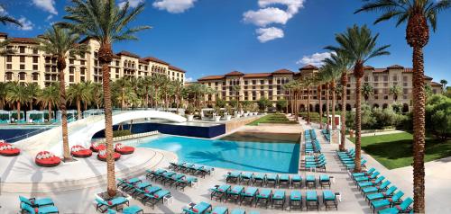 a resort with a pool and palm trees and chairs at Green Valley Ranch Resort Spa Casino in Las Vegas