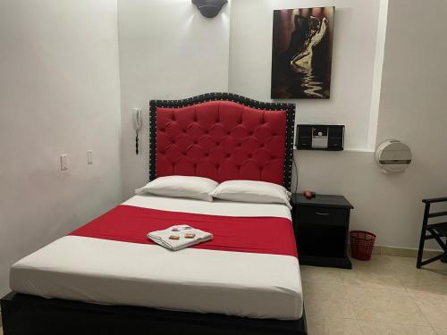 a bedroom with a large bed with a red headboard at Residencias del Oriente in Bucaramanga