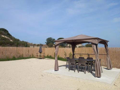 a gazebo with chairs and a table in the sand at Glamping Pod in Prodhromi