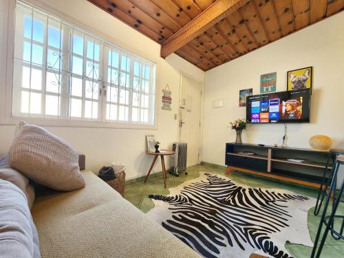 uma sala de estar com um sofá e um tapete de zebra em Quatro Estacoes Hospeda -Vila 01 , sua casa em Campos do Jordao, a 1 km do centro turistico em Campos do Jordão