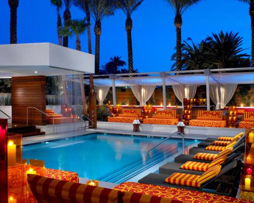 a pool with lounge chairs and palm trees at night at Green Valley Ranch Resort Spa Casino in Las Vegas