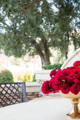 a vase filled with red flowers sitting on a table at Green Valley Ranch Resort Spa Casino in Las Vegas