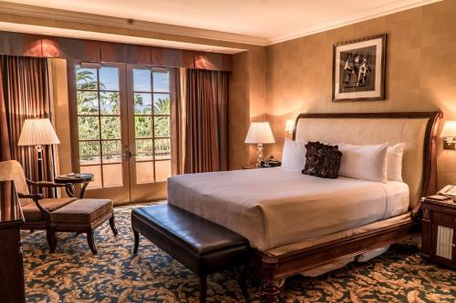 a bedroom with a bed and a chair and a window at Green Valley Ranch Resort Spa Casino in Las Vegas