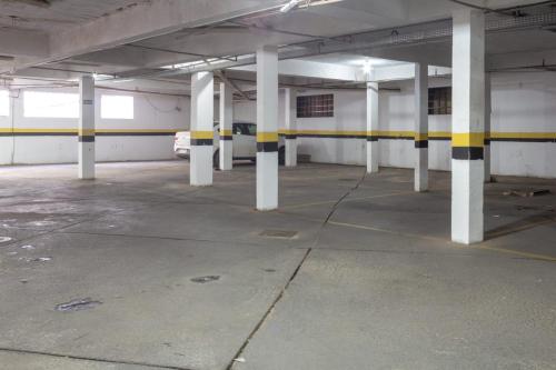 an empty parking garage with white and yellow columns at Hotel Terra Cedro In in Goiânia
