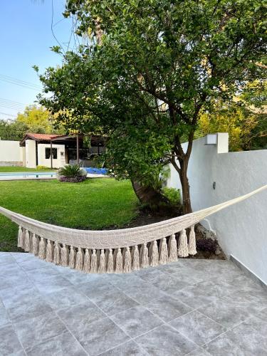 a bench next to a tree next to a wall at VILLA AMATE DORADO in Xochitepec