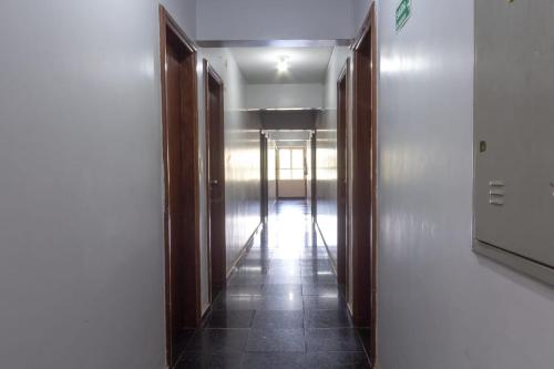a hallway with wooden doors and a tile floor at Hotel Terra Cedro In in Goiânia
