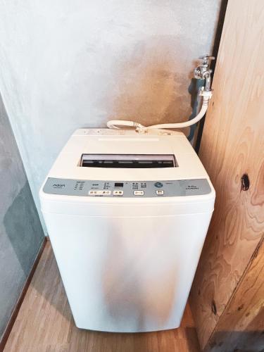 a white toilet in a bathroom next to a door at Kamifurano House in Kami-furano