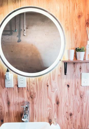 a mirror hanging on a wooden wall in a bathroom at Kamifurano House in Kami-furano