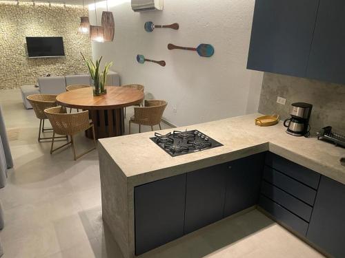 a kitchen with a stove and a table with chairs at Casa Nazar in São Miguel dos Milagres