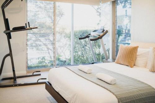 a bedroom with a bed and a large window at 11 East Gosford Luxury Waterfront House with Private Wharf in Gosford