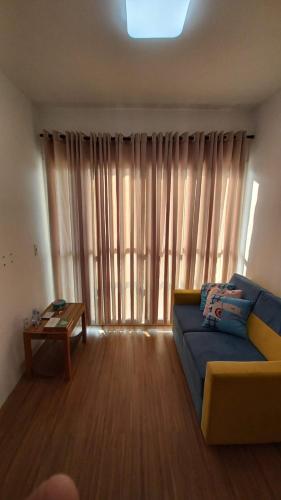 sala de estar con sofá azul frente a una ventana en Apto para 03 hospedes nao aceito pet, en Tatuí