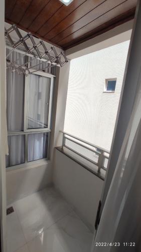 ein leeres Zimmer mit einem Fenster und einem Balkon in der Unterkunft Paraíso Peracanga - Bacutia in Guarapari