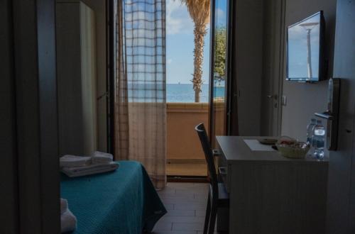 クロトーネにあるB&B Benvenuti al Sudのテーブル付きの客室で、海の景色を望めます。