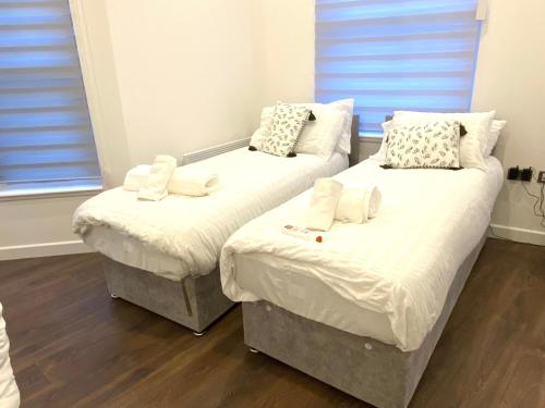 two twin beds in a room with wood floors at Buckinghamshire Elegant Studio in Buckinghamshire