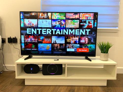 a flat screen tv sitting on a white stand at Buckinghamshire Elegant Studio in Buckinghamshire