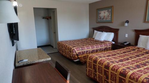 Habitación de hotel con 2 camas y TV en Travel Inn Tucson, en Tucson