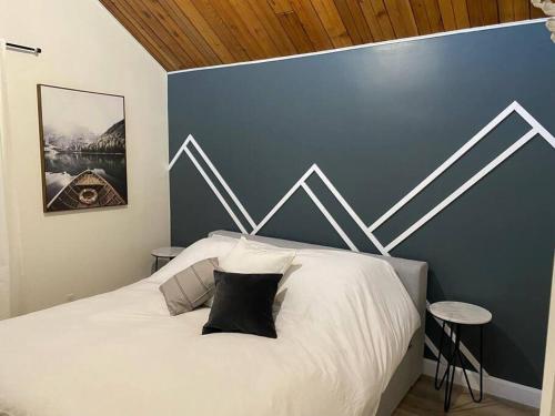 ein Schlafzimmer mit einem weißen Bett und einer blauen Wand in der Unterkunft Charming Nordic Style - 2BR + 1 Bath Entire House in Sudbury