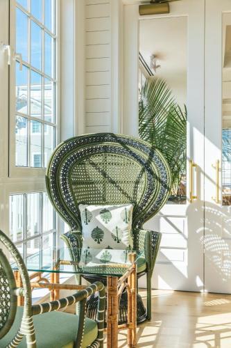 a porch with a wicker chair and a table at Gardiner House in Newport