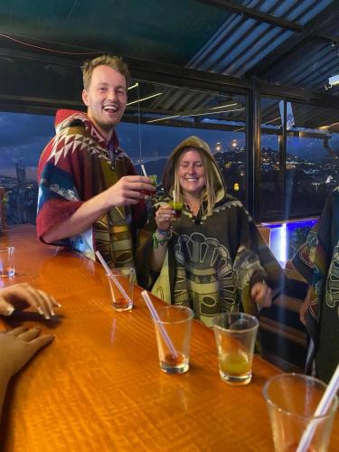 a man and woman sitting at a table with drinks at Hostal La Guayunga RoofTop in Quito