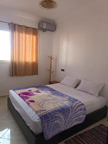 - une chambre avec un grand lit et une couverture dans l'établissement Appartement Sariq Ouarzazate, à Ouarzazate